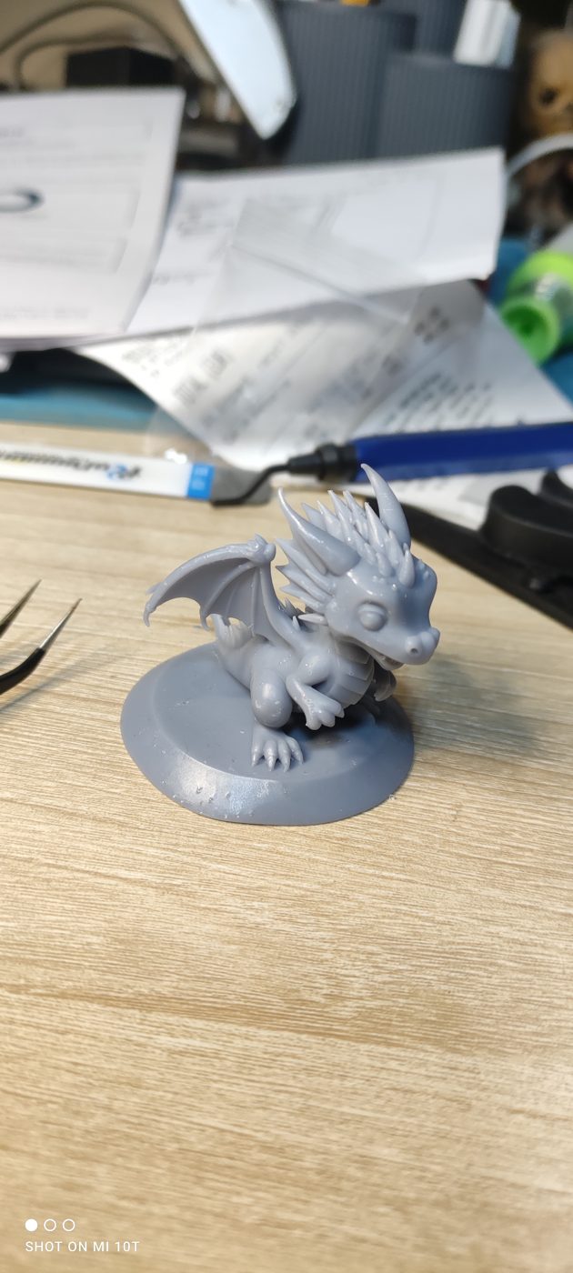 Figurine de dragon imprimée en 3D, posée sur son socle rond